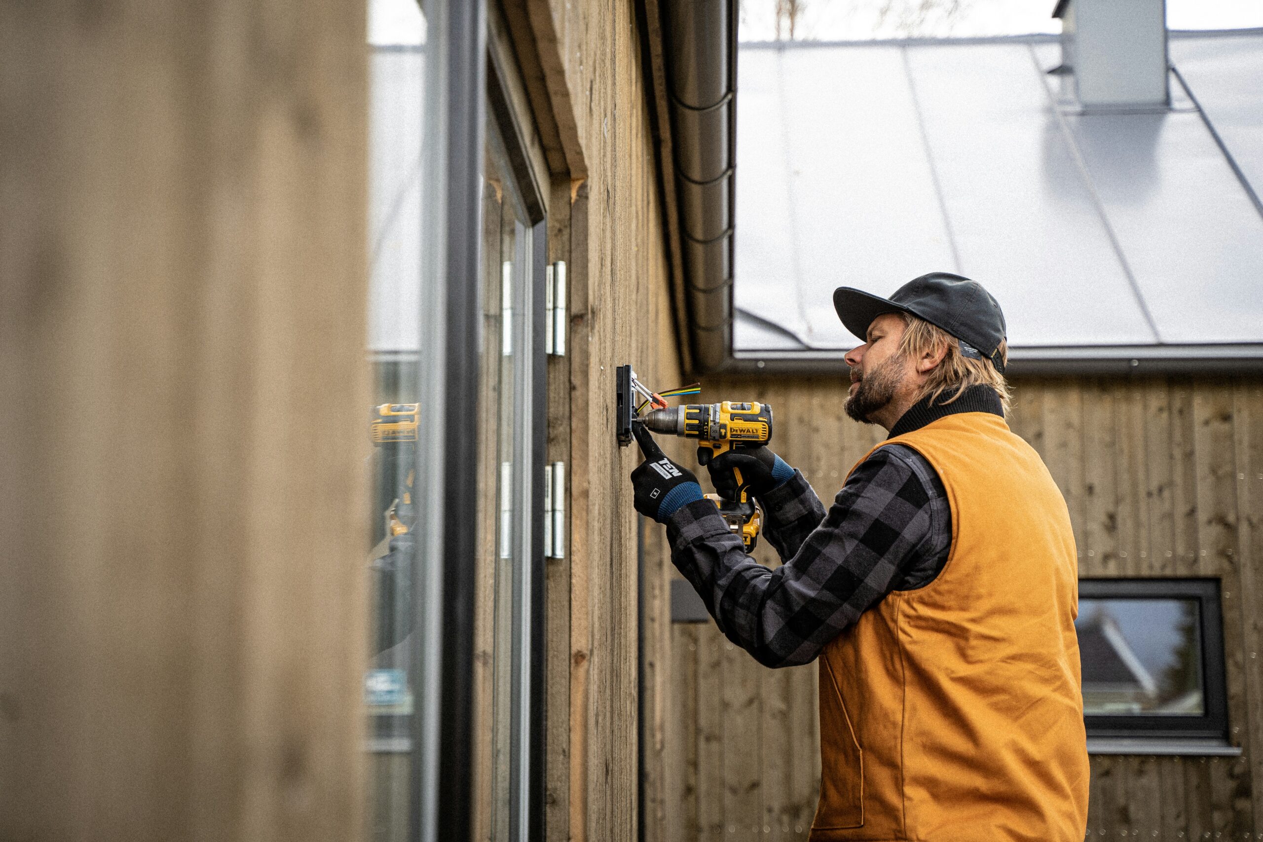 Mand installerer elbil lader på hus